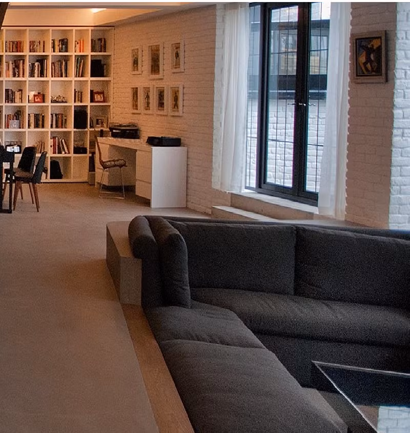 Phòng khách chìm được thiết kế giữa sàn nhà bê tông nhẵn, đối lập với lối kiến trúc tường gạch xung quanh.