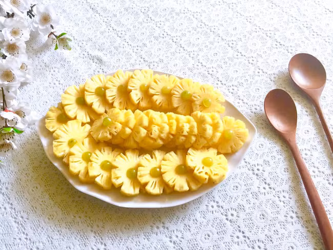  Với dứa (thơm) chị cắt khoanh tròn để tỉa thành các cánh hoa, bỏ phần lõi và thêm nho làm thành nhụy hoa.