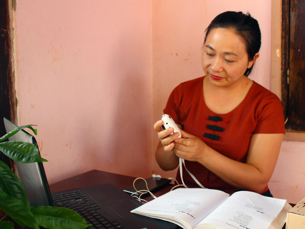 Chị Đinh Thị Phương Chi kiểm tra loa trước khi gửi đi cho các phụ huynh. Ảnh: N.G