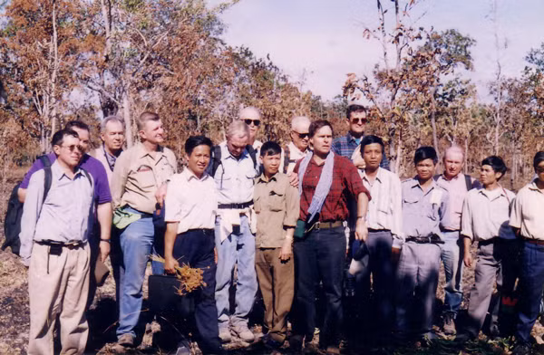 Tướng Harold Moore (người cúi đầu) cùng các cựu chiến binh Mỹ chụp ảnh lưu niệm với cán bộ huyện Chư Prông tại thung lũng Ia Drăng năm 1997. Ảnh: N.T