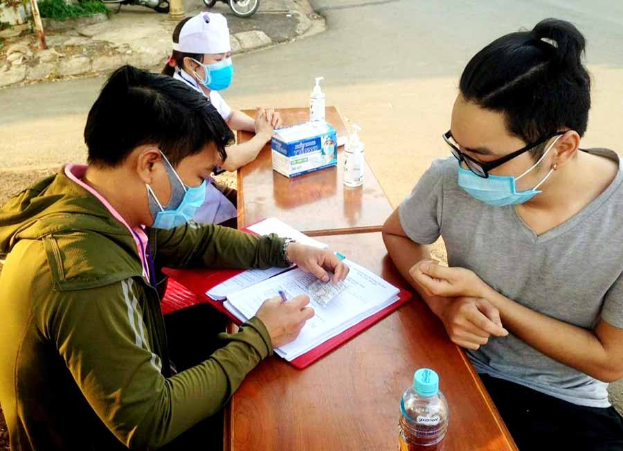 Cán bộ phường Đống Đa hỗ trợ người dân ghi thông tin khai báo y tế. Ảnh: Minh Nguyễn