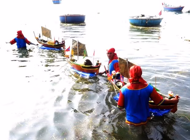 Nghi thức thả thuyền tế ra biển. (Ảnh: Phước Ngọc/TTXVN)