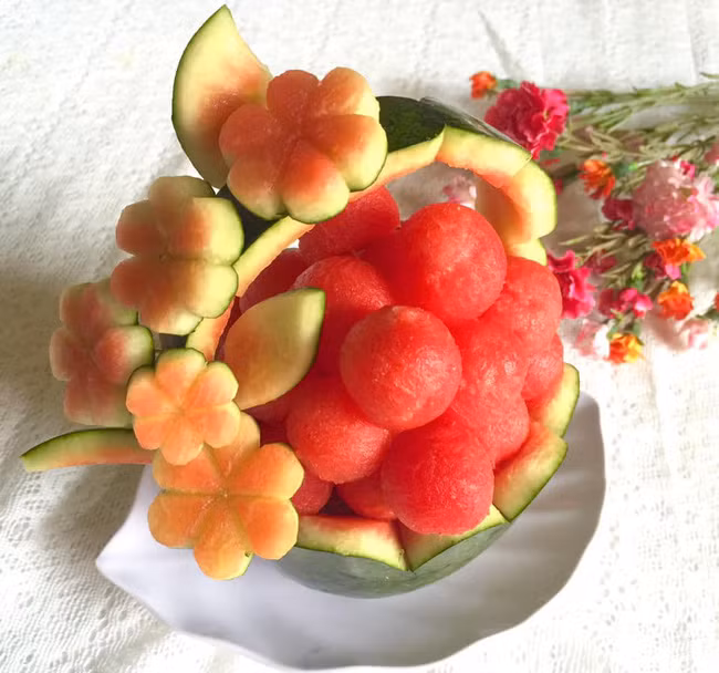 Cầu kỳ hơn, chị Thủy nạo hết ruột dưa hấu ra, múc thành các viên tròn, phần vỏ cắt tỉa để tạo ra giỏ hoa 