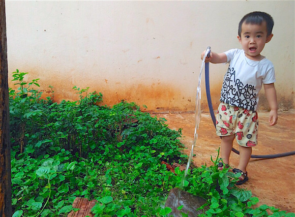 Bé Trịnh Tiến Quốc (xã Biển Hồ, TP. Pleiku) giúp mẹ tưới rau. Ảnh: M.T