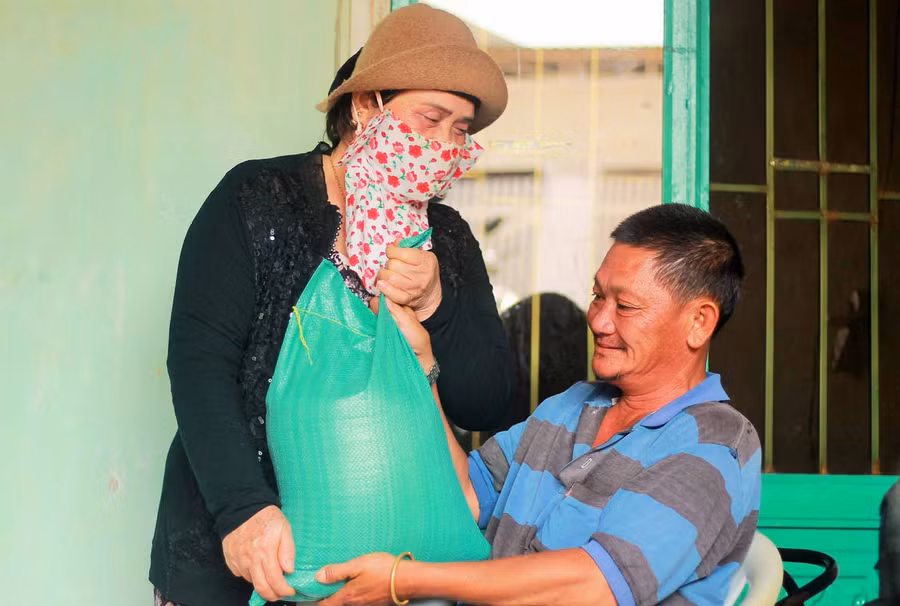 Nhà hảo tâm tặng gạo cho ông Đặng Thanh Vũ. Ảnh: Hà Phương