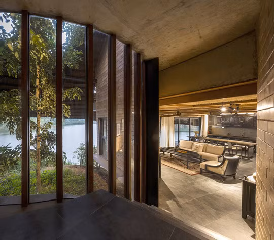 Phòng khách có sàn thấp hơn lối vào do bám theo nền đất dốc, tạo ra không gian độc đáo hơn.