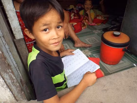 Niềm vui vừa học được chữ cái mới rạng ngời trên gương mặt em N.N.T. (8 tuổi, xóm nhà trọ ven đường Nguyễn Văn Linh, xã Bình Hưng, huyện Bình Chánh).