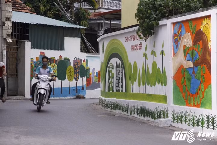 Chỉ dài hơn 200m, nhưng trên những bức tường nhà nằm ven con nhỏ có hàng chục bức tranh đầy màu sắc về cây đa, giếng nước, mái đình...