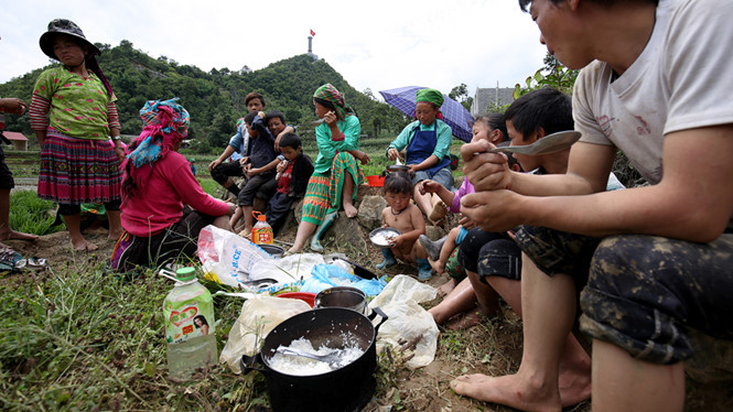 Nhiều gia đình cùng góp cơm ăn chung, phía sau họ là Cột cờ Lũng Cú.
