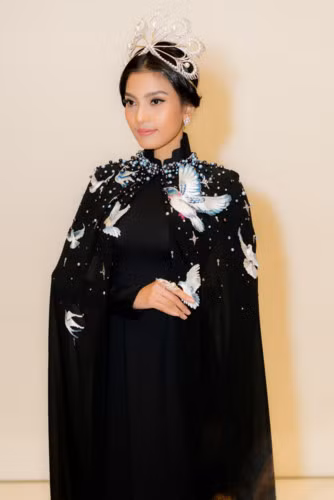 Với vai trò vedette, Trương Thị May diện một thiết kế áo dài đặc biệt với phần áo choàng bên ngoài được đính kết cầu kỳ và nhiều chi tiết thêu tay tỉ mỉ, ấn tượng.