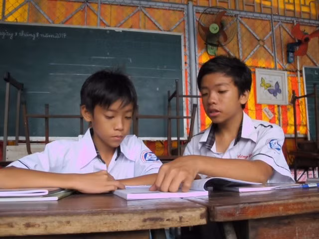 Hai anh em Huỳnh Công Phát (phải) và Huỳnh Công Danh cùng học bài.