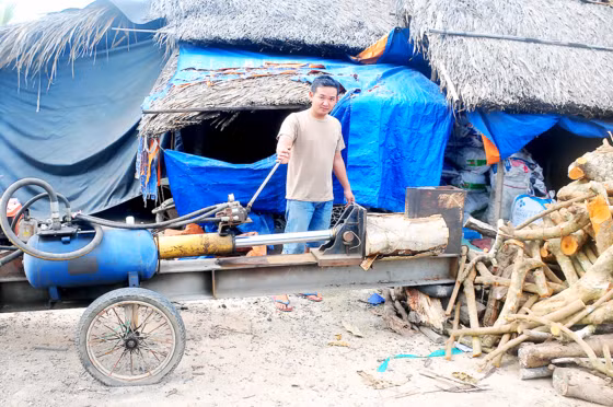 Anh Nhiều điều khiển máy chẻ củi do mình chế tạo.