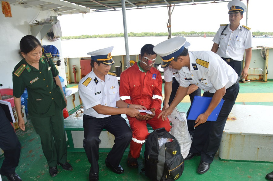  Ngư dân Nguyễn Văn Việt (áo đỏ, ngồi giữa) nhận quà động viên của hải đoàn 129. Ảnh: Thế Duy