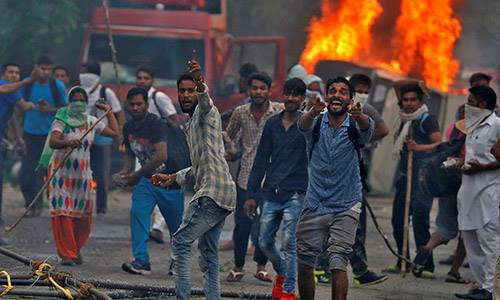 Người biểu tình ủng hộ giáo sĩ Singh đốt phá hôm 25-8. Ảnh: Reuters Người biểu tình ủng hộ giáo sĩ Singh đốt phá hôm 25-8. Ảnh: Reuters