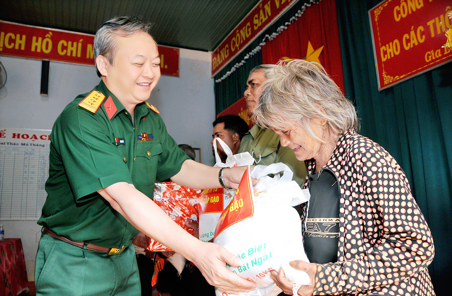  Đại tá Hoàng Văn Sỹ-Tư lệnh Binh đoàn 15 tặng quà cho các hộ có hoàn cảnh khó khăn. Ảnh: Vĩnh Hoàng