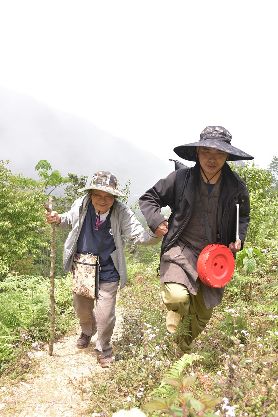 Họa sư Trương Lộ (trái), đã ngoài 70, cũng không nghĩ rằng mình có thể leo lên các dốc núi cao đi sáng tác.