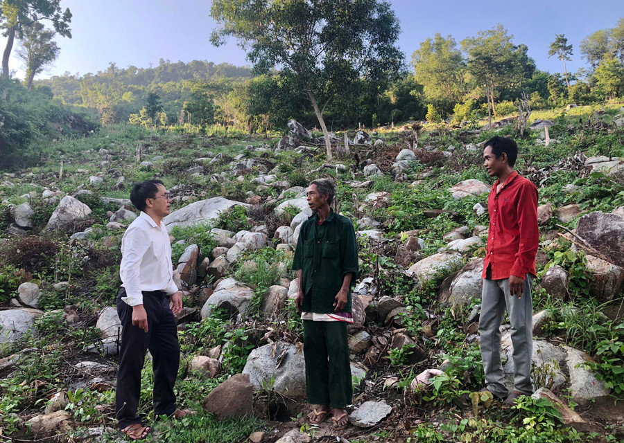 Ông Trịnh Thanh Khiết-Bí thư Đảng ủy xã Đất Bằng (bìa trái) trao đổi với người dân về chuyển đổi đất nương rẫy sang trồng rừng. Ảnh: Lê Nam