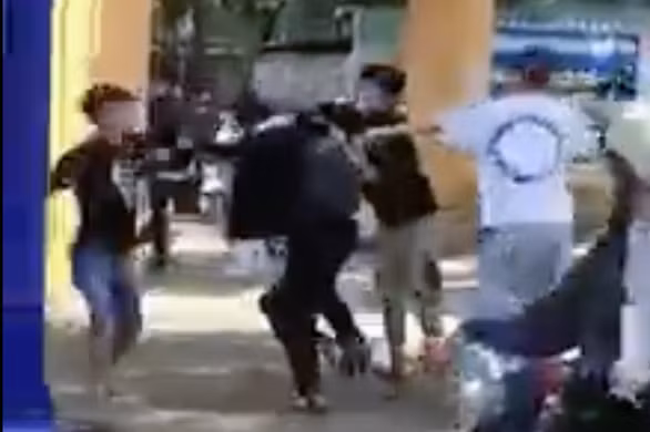 Nam sinh lớp 12 ở Bình Phước bị vây đánh trước cổng trường. Ảnh cắt từ clip