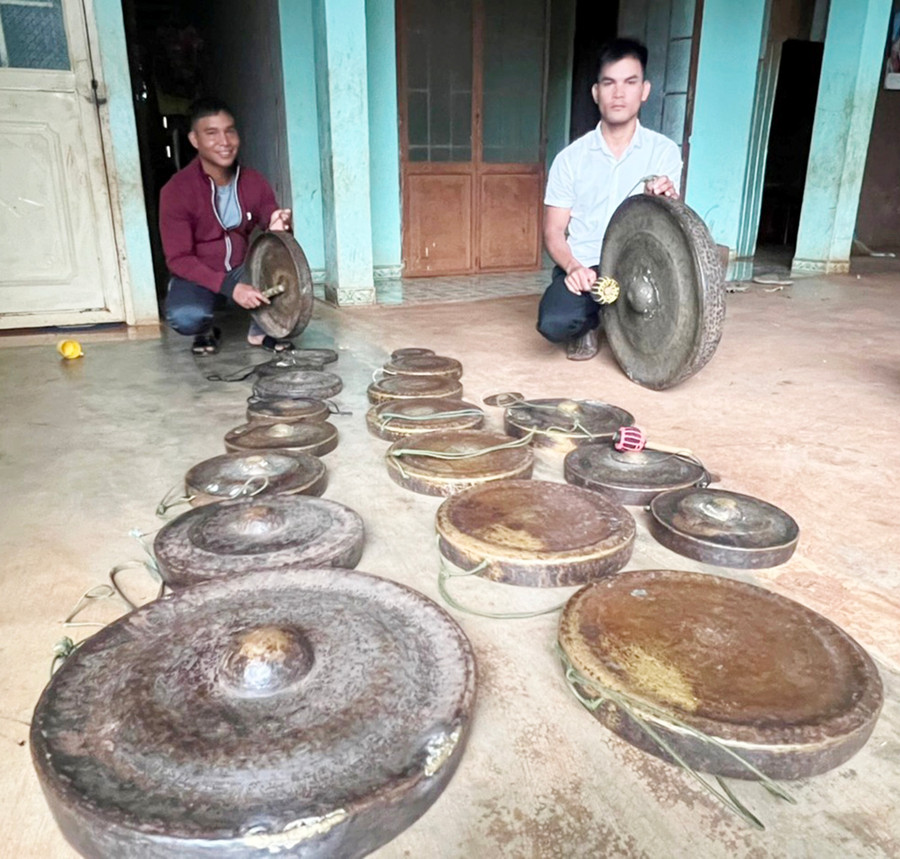 Anh Rơ Lan Đông (bìa phải)-Đội trưởng đội cồng chiêng làng Chuet Ngol (xã Chư Á) kiểm tra chiêng trước mỗi buổi dạy thanh-thiếu nhi trong làng. Ảnh: Đinh Yến  Anh Rơ Lan Đông (bìa phải)- Đội trưởng đội cồng chiêng làng Chuet Ngol (xã Chư Á) kiểm tra ching, chiêng cho mỗi buổi dạy thanh-thiếu nhi trong làng. Ảnh: Đinh Yến