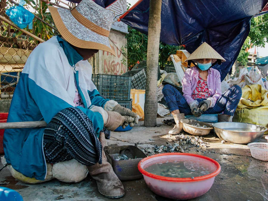 Những người phụ nữ ngồi cạy hàu ven đường là hình ảnh quen thuộc khi đặt chân đến TT.Quán Hàu