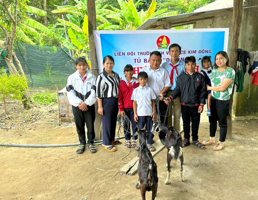 Em Đinh Thị Hoặch (bìa trái) cùng các em phấn khởi đón nhận cặp dê sinh sản từ 