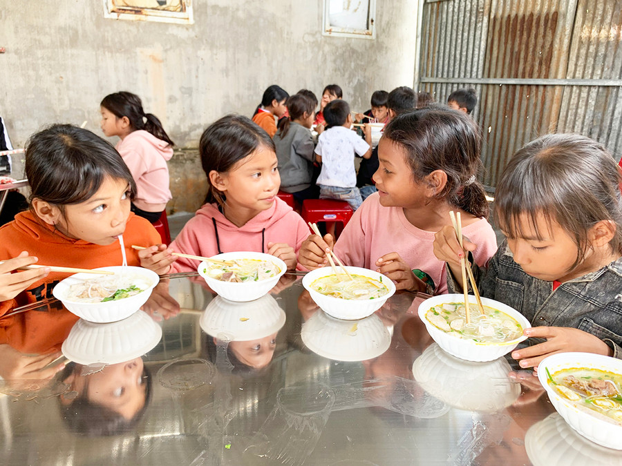 Các em học sinh thưởng thức bữa trưa do các anh, chị đoàn viên nấu. Ảnh: Như Nguyện