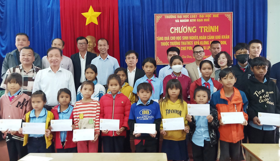 Các em học sinh nhận quà của Trường Đại học Luật-Đại học Huế. Ảnh: Huyền Ly