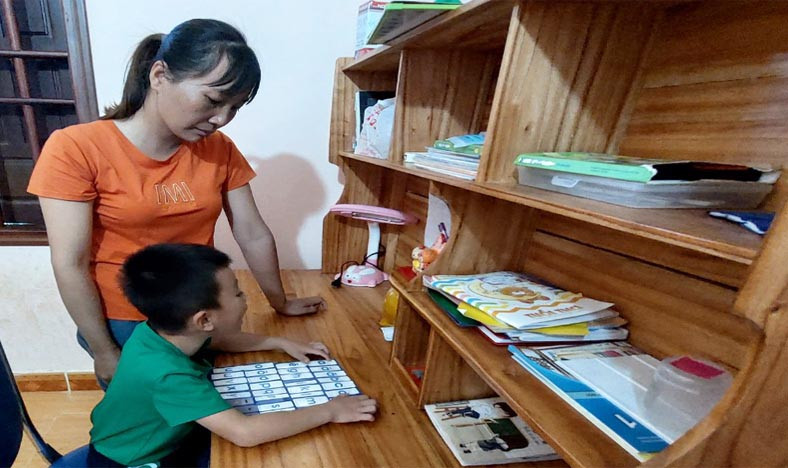 Chị Phùng Thị Ngọc dạy con học bài. Ảnh: Vĩnh Hoàng