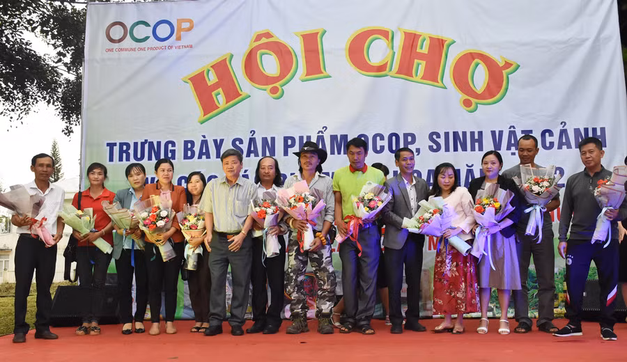 Lãnh đạo huyện Mang Yang tặng hoa cho các đơn vị tham gia tại hội chợ triển lãm. Ảnh: Hà Phương