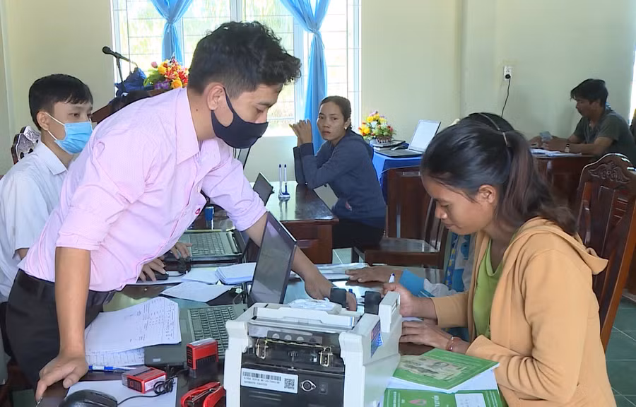 Nhân viên Phòng Giao dịch Ngân hàng CSXH huyện hướng dẫn người dân làm thủ tục vay vốn ưu đãi. Ảnh: Lê Nam