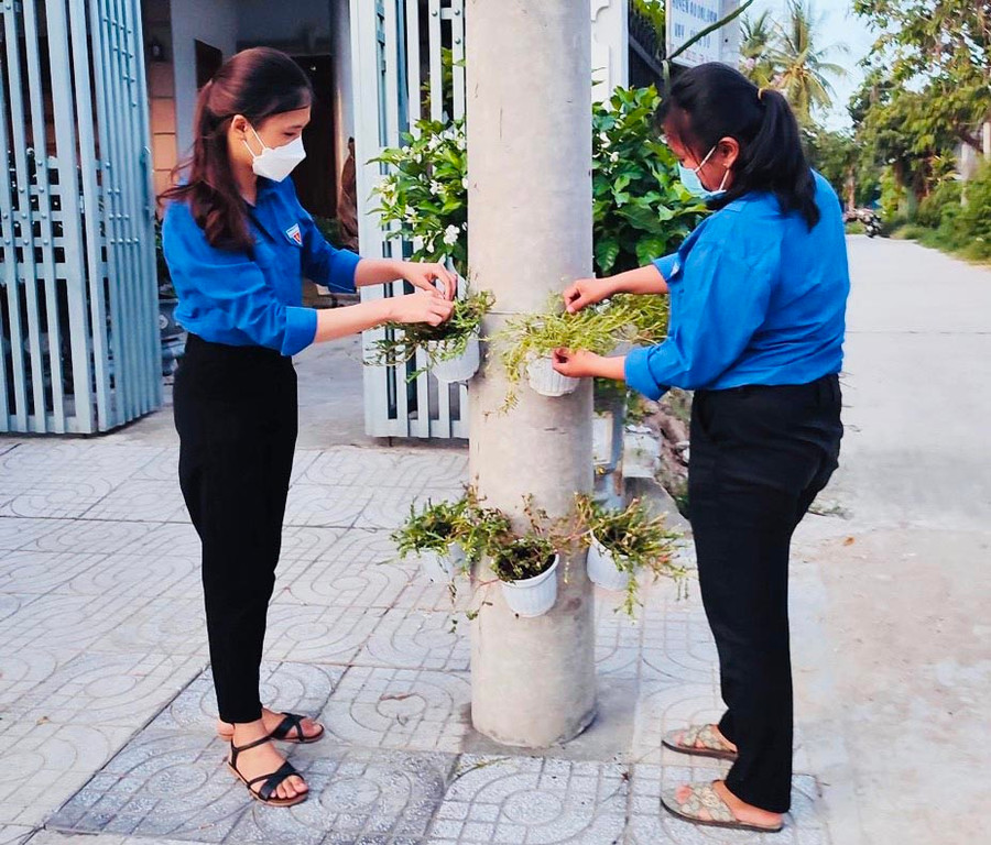 Đoàn viên, thanh niên thị trấn Phú Túc ra quân trang trí giỏ hoa mười giờ trên các cột điện của tuyến đường Quang Trung tạo cảnh quan xanh-sạch-đẹp. Ảnh: Vũ Chi