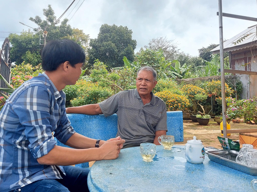 Ông Hmrik (bìa phải) kể chuyện về cây đa của làng Ia Nueng. Ảnh: Hoành Sơn