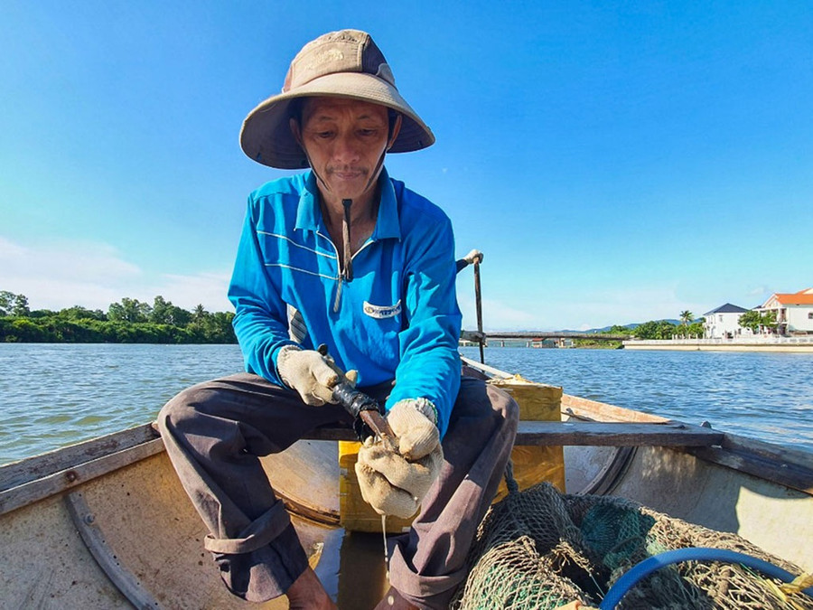 Ông Đán cũng từng là một “Yết Kiêu” của làng, giờ đã có tuổi, công việc của ông là ở trên thuyền tách hàu. Ảnh: Bá Cường