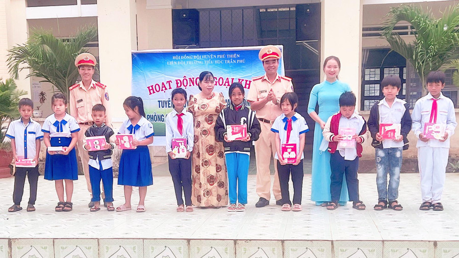 Tặng quà cho học sinh trả lời đúng câu hỏi về an toàn giao thông. Ảnh: Kỳ Anh