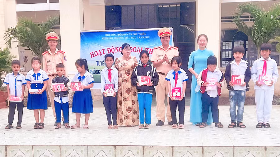 Tặng quà cho học sinh trả lời đúng câu hỏi về an toàn giao thông. Ảnh: Kỳ Anh