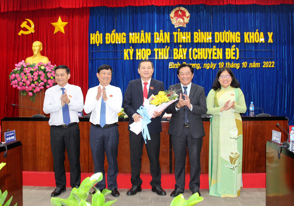Ông Phạm Văn Chánh (giữa) nhận hoa từ các lãnh đạo tỉnh Bình Dương. Ảnh: B.S/Tuổi Trẻ