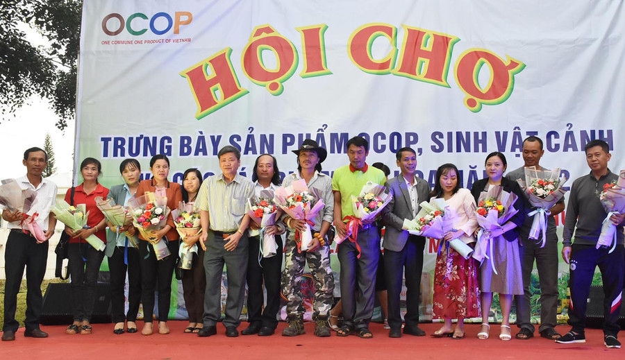 Lãnh đạo huyện Mang Yang tặng hoa cho các đơn vị tham gia Hội chợ trưng bày sản phẩm OCOP, sinh vật cảnh và các tác phẩm hội họa năm 2022. Ảnh: Hà Phương