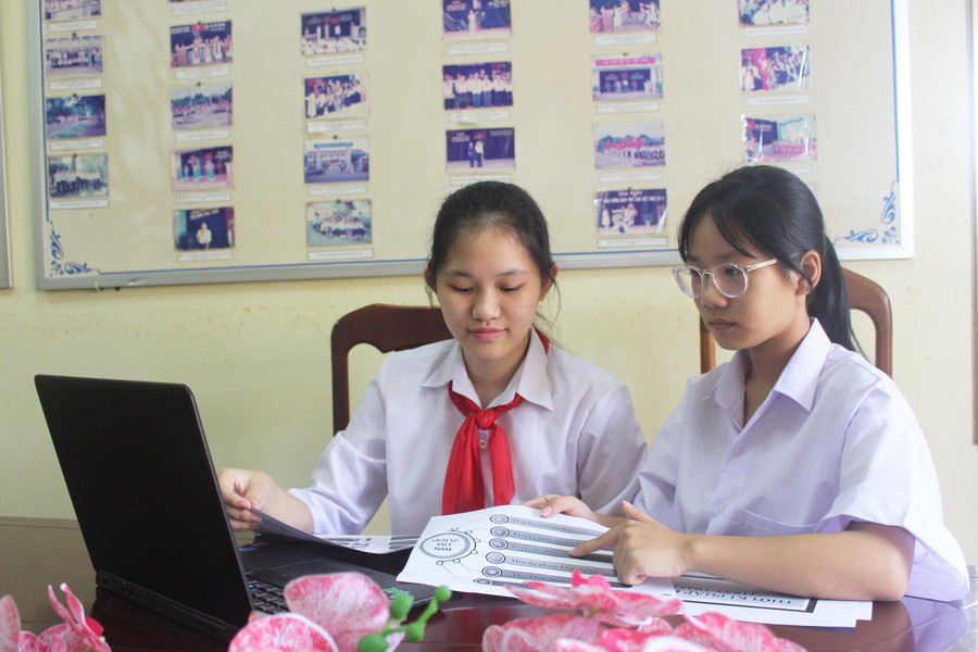 Em Trương Thị Thúy An (bìa trái) và em Nguyễn Dương Diệp Linh đang bổ sung dữ liệu vào phần mềm “Tra cứu lịch sử Việt Nam”. Ảnh: Minh Nhật