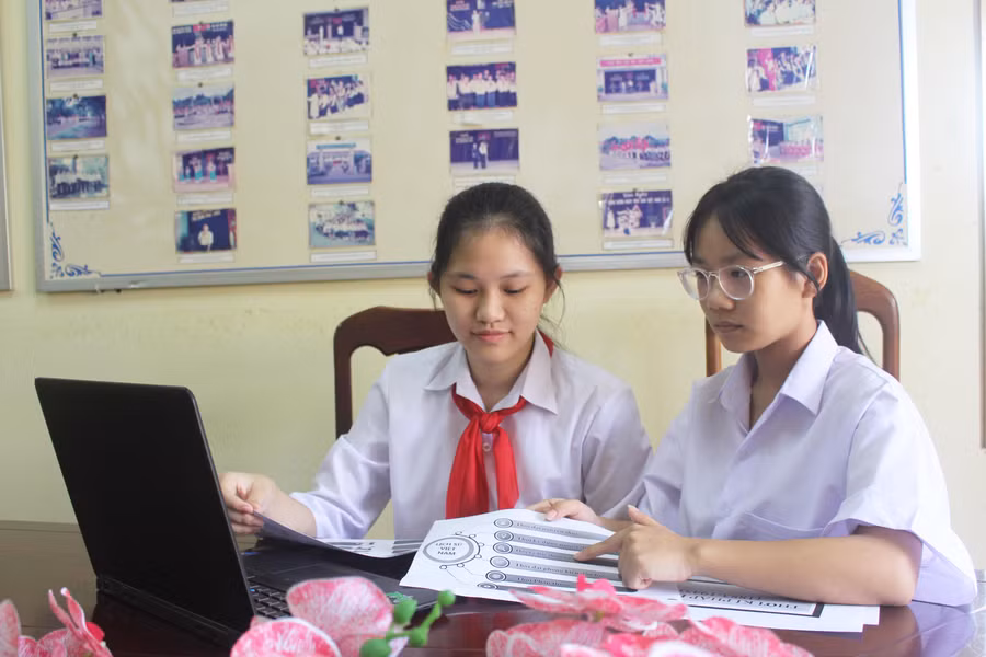Em Trương Thị Thúy An (bìa trái) và em Nguyễn Dương Diệp Linh đang bổ sung dữ liệu vào phần mềm “Tra cứu lịch sử Việt Nam”. Ảnh: Minh Nhật