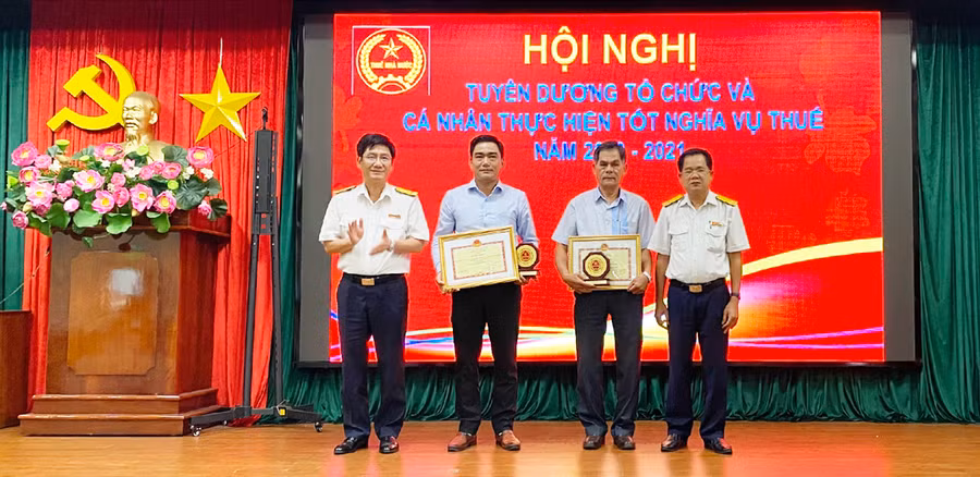 Lãnh đạo Cục Thuế tỉnh trao tặng bằng khen của Bộ Tái chinh cho hai doanh nghiệp đã có thành tích tiêu biểu trong thực hiện nghĩa vụ thuế đối với ngân sách Nhà nước. Ảnh: Sơn Ca