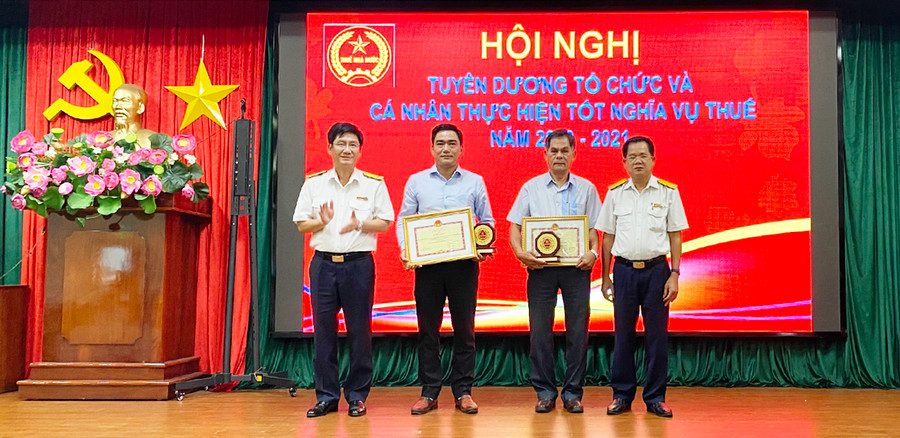 Lãnh đạo Cục Thuế tỉnh trao tặng bằng khen của Bộ Tái chinh cho hai doanh nghiệp đã có thành tích tiêu biểu trong thực hiện nghĩa vụ thuế đối với ngân sách Nhà nước. Ảnh: Sơn Ca