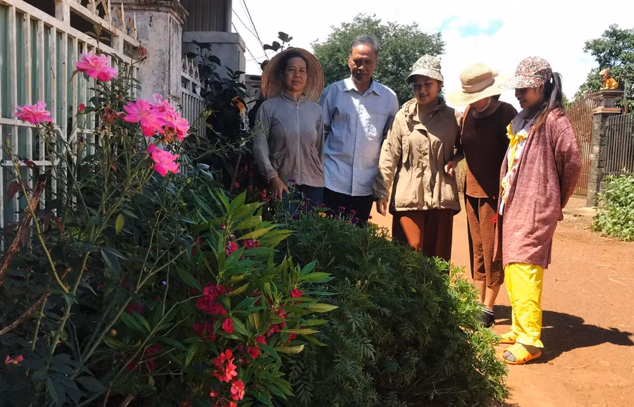 Ông Lick vận động phụ nữ làng Piơm (thị trấn Đak Đoa) xây dựng con đường hoa. Ảnh: Nguyễn Diệp