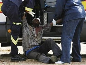 Nhân viên cứu hộ giúp đỡ một nạn nhân của làn sóng bài ngoại ở khu ngoại ô Reiger Park, Johannesburg.