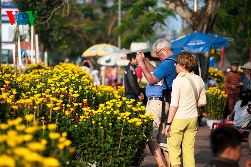 Du khách nước ngoài lưu lại hình ảnh tại chợ hoa Xuân