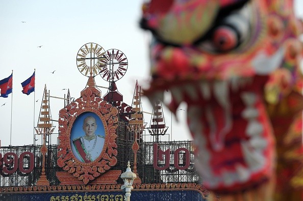 Một nghệ sĩ lân sư rồng biểu diễn ở quảng trường trước cung điện hoàng gia Campuchia, đằng sau là chân dung Quốc vương Norodom Sihamoni vào ngày 30 Âm lịch.