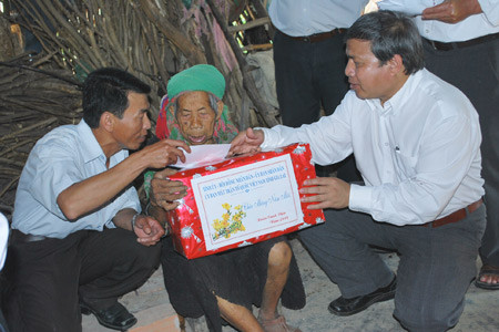 Phó Chủ tịch UBND tỉnh Măng Đung (bên phải), tặng quà cho bà Dương Thị Sấy. Ảnh: T.H