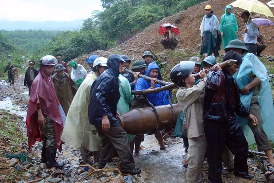 Trời mưa nhưng các chiến sĩ công binh vẫn phối hợp nhịp nhàng di chuyển bom 270 cân anh đến bãi tiêu hủy an toàn. Ảnh: Bùi Oanh Trời mưa nhưng các chiến sĩ công binh vẫn phối hợp nhịp nhàng di chuyển bom 270 bảng anh đến bãi tiêu hủy an toàn. Ảnh: Bùi Oanh