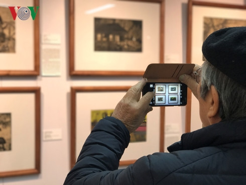 Du khách hào hứng chiêm ngưỡng tranh của hoạ sĩ Nguyễn Thụ.