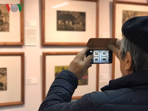 Du khách hào hứng chiêm ngưỡng tranh của hoạ sĩ Nguyễn Thụ.