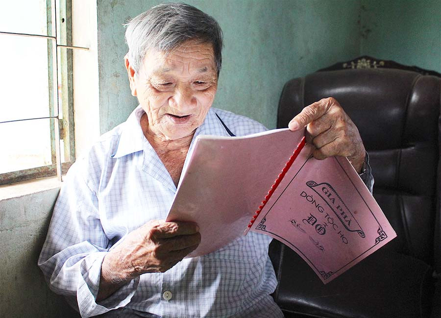  Ông Đỗ Nhân đang đọc lại phần ghi chép về liệt sĩ Đỗ Trạc từ cuốn gia phả của dòng tộc. Ảnh: H.T